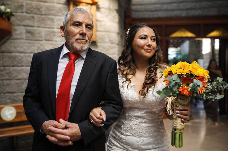 Momento emotivo donde el padre acompaña a la novia durante su entrada a la ceremonia.